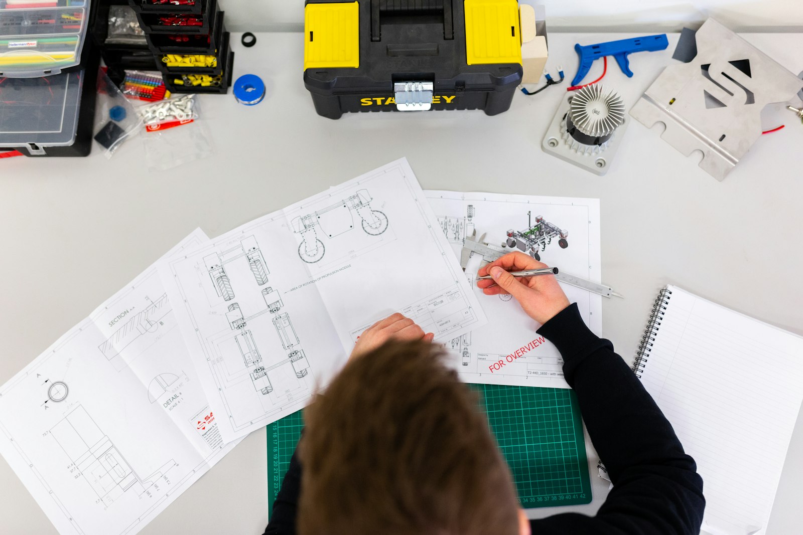 Technical drawings and tools laid out on a workbench