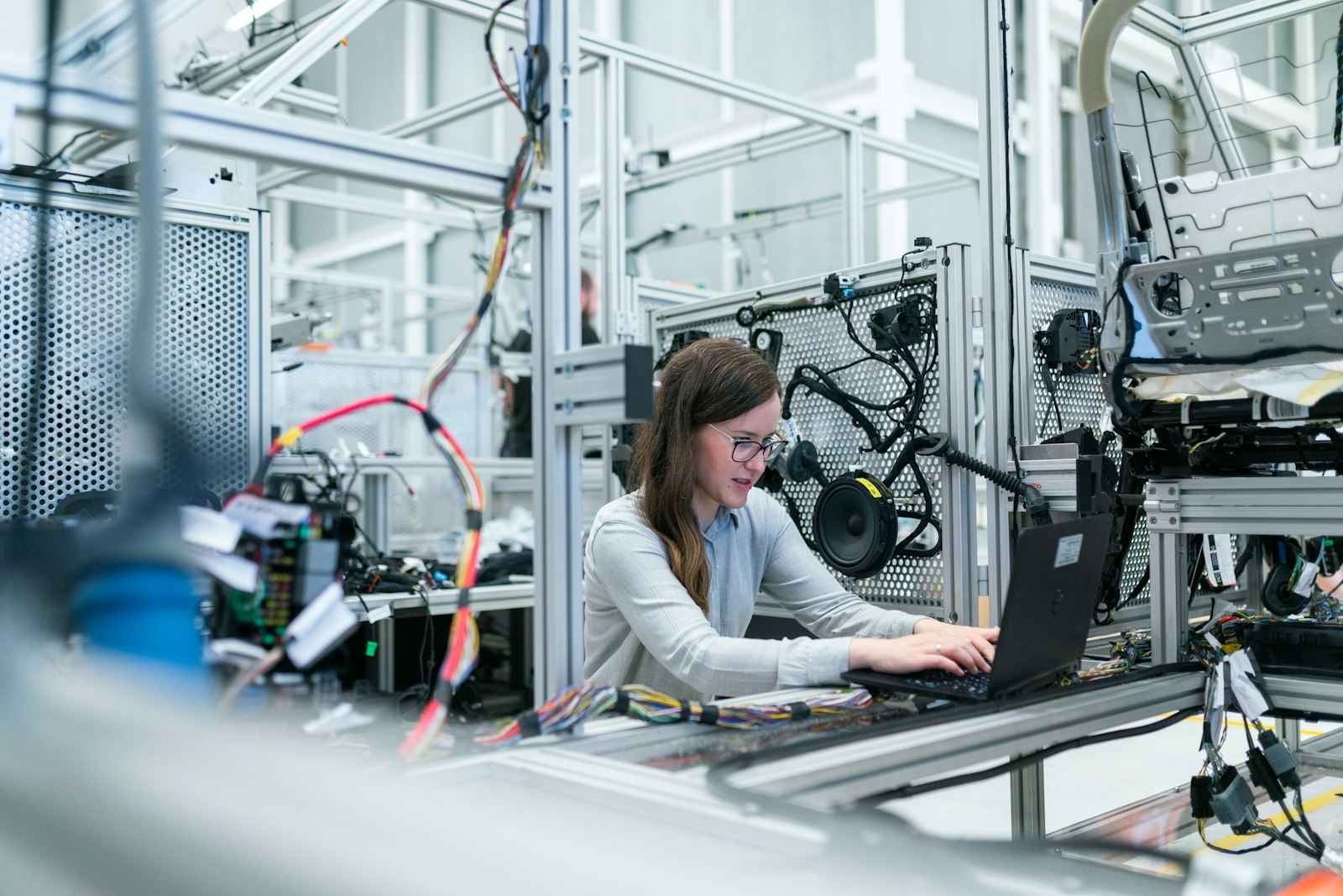 Engineer working at a laptop on a factory production line