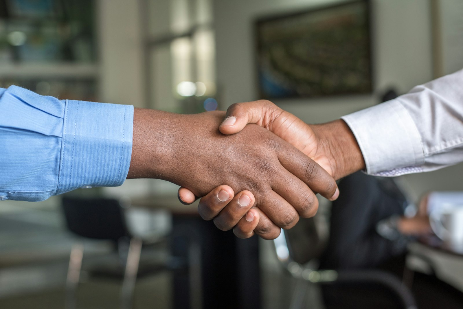 Two people shaking hands over a business agreement