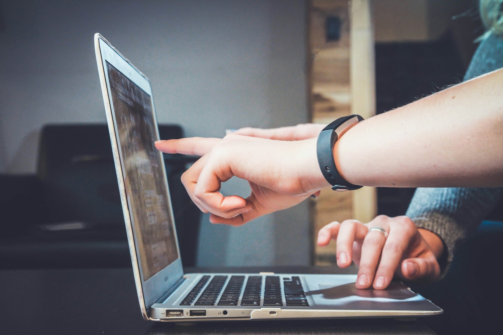 Person pointing at a laptop screen during a review