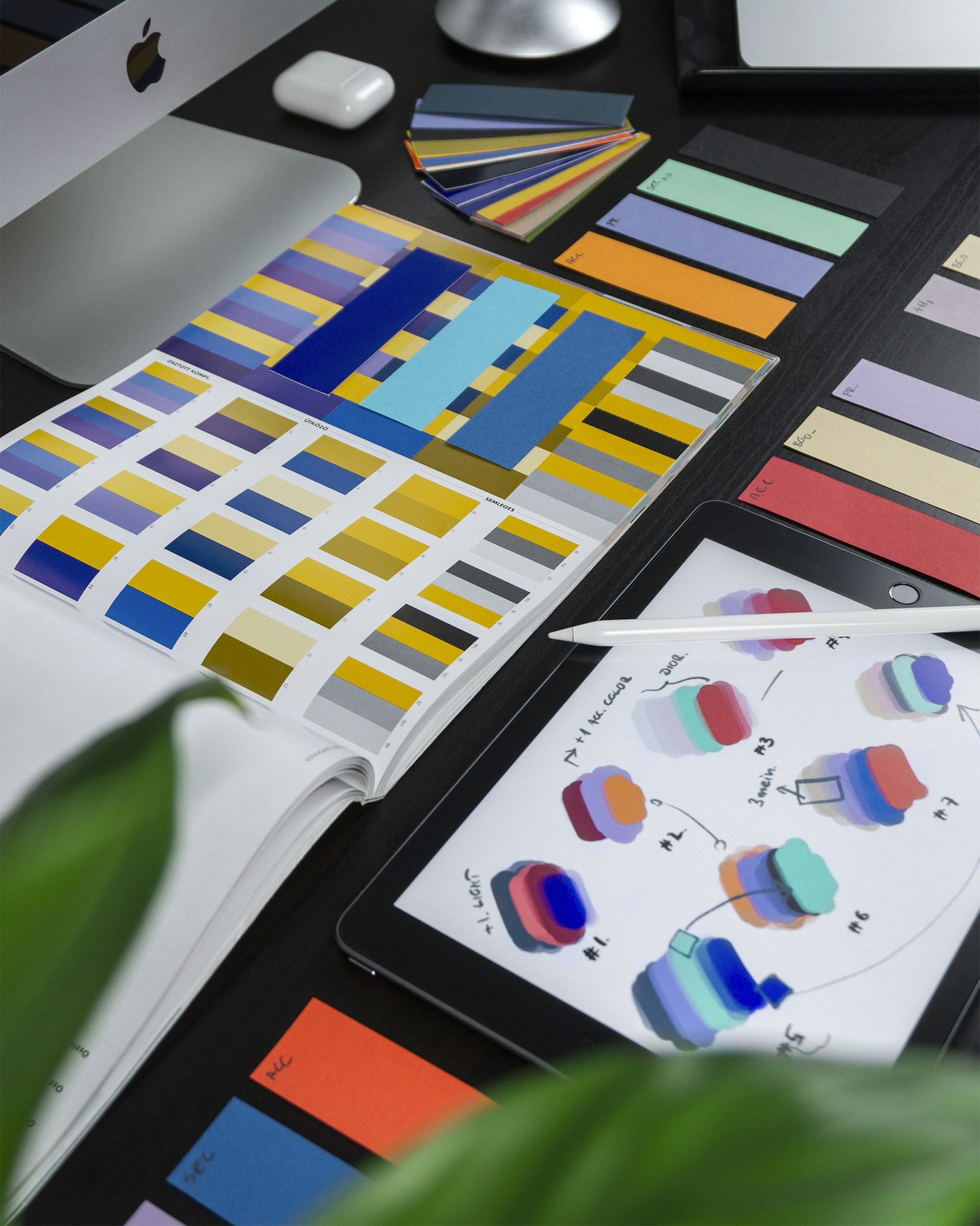 Color palette swatches and interface sketches spread across a desk